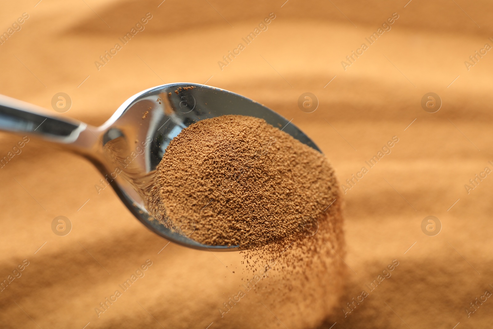 Photo of Spoon with aromatic instant coffee as background, closeup