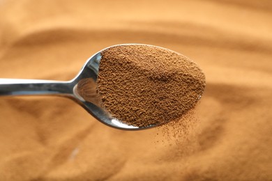 Photo of Spoon with aromatic instant coffee as background, closeup