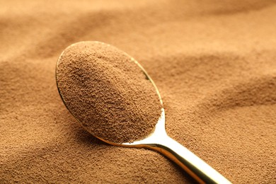 Photo of Spoon with aromatic instant coffee as background, closeup