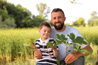 Photo of Father and his son planting tree outdoors