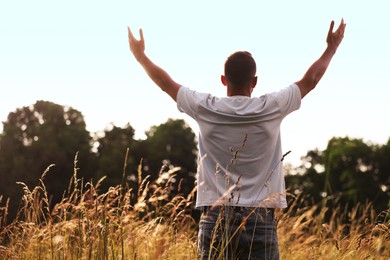 Photo of Feeling freedom. Man enjoying time outdoors, back view. Space for text