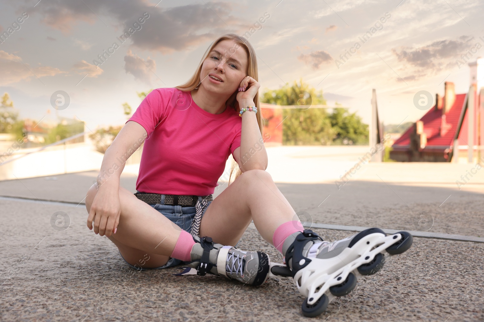 Happy woman with roller skates on street Photo of Happy woman with roller skates on street