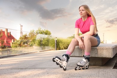 Photo of Happy woman with roller skates on street. Space for text