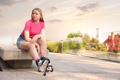 Photo of Happy woman with roller skates on street. Space for text