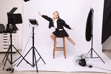Photo of Little girl on white background in photo studio with professional equipment