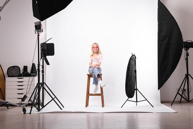 Photo of Little girl on white background in photo studio with professional equipment
