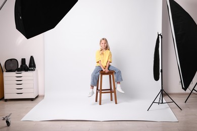 Photo of Little girl on white background in photo studio with professional equipment