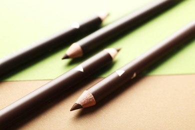 Photo of Brown eyebrow pencils on color background, closeup