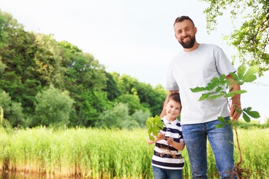 Photo of Father and his son planting tree outdoors, space for text