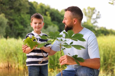 Photo of Father and his son planting tree outdoors