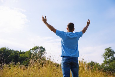 Photo of Feeling freedom. Man enjoying time outdoors, back view. Space for text