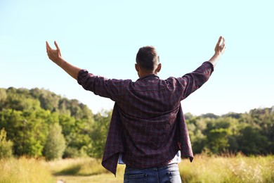 Photo of Feeling freedom. Man enjoying time outdoors, back view