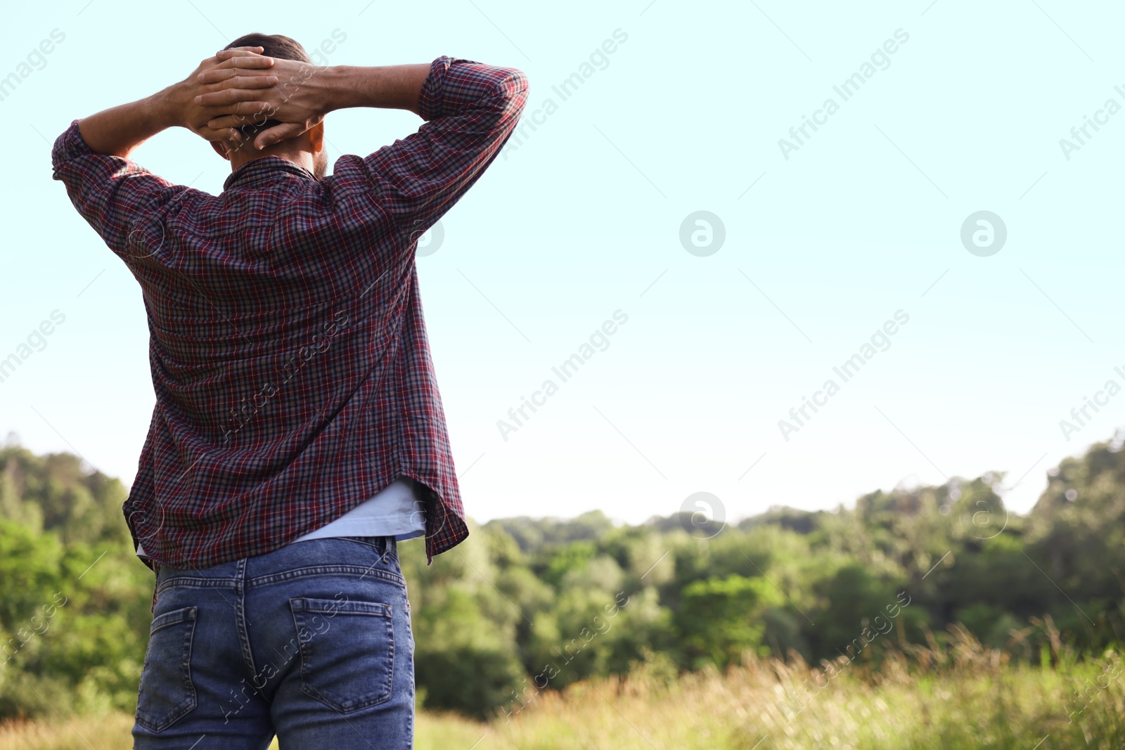 Feeling freedom. Man enjoying time outdoors, back view. Space for text Photo of Feeling freedom. Man enjoying time outdoors, back view. Space for text