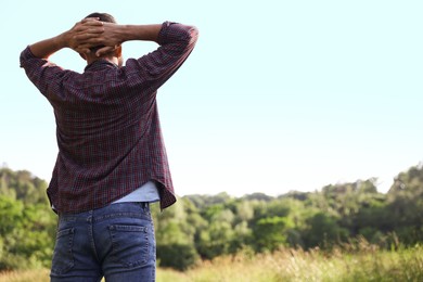Photo of Feeling freedom. Man enjoying time outdoors, back view. Space for text