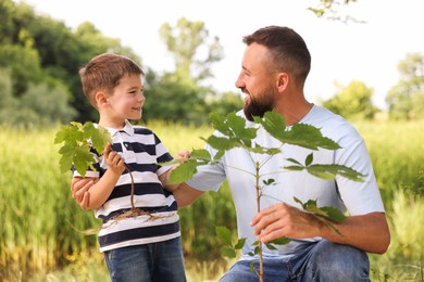 Photo of Father and his son planting tree outdoors