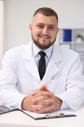 Photo of Portrait of doctor in uniform at table indoors