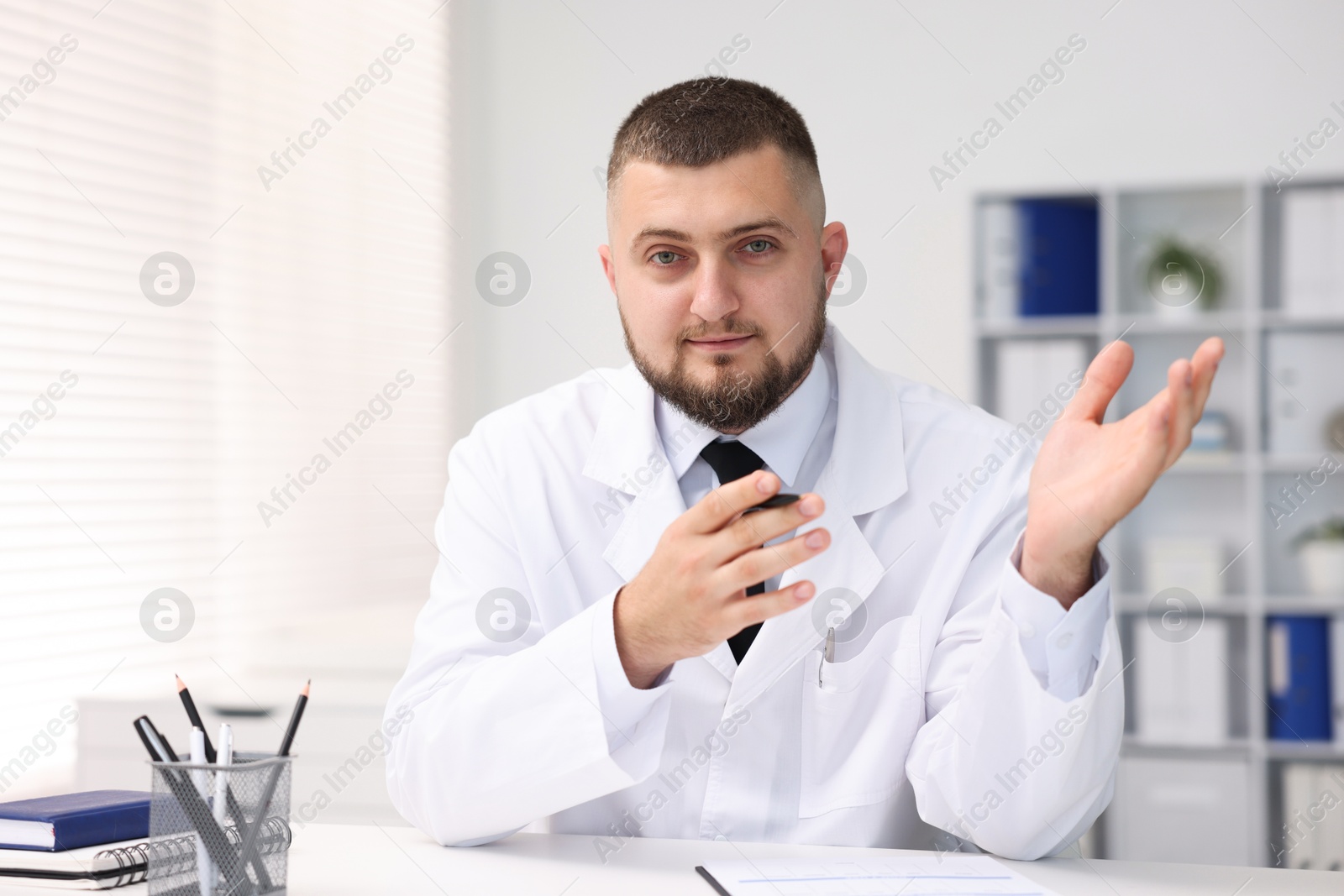 Portrait of doctor in uniform at table indoors Photo of Portrait of doctor in uniform at table indoors
