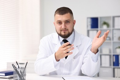 Photo of Portrait of doctor in uniform at table indoors