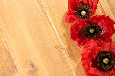 Photo of Beautiful red poppy flowers on wooden table, flat lay. Space for text