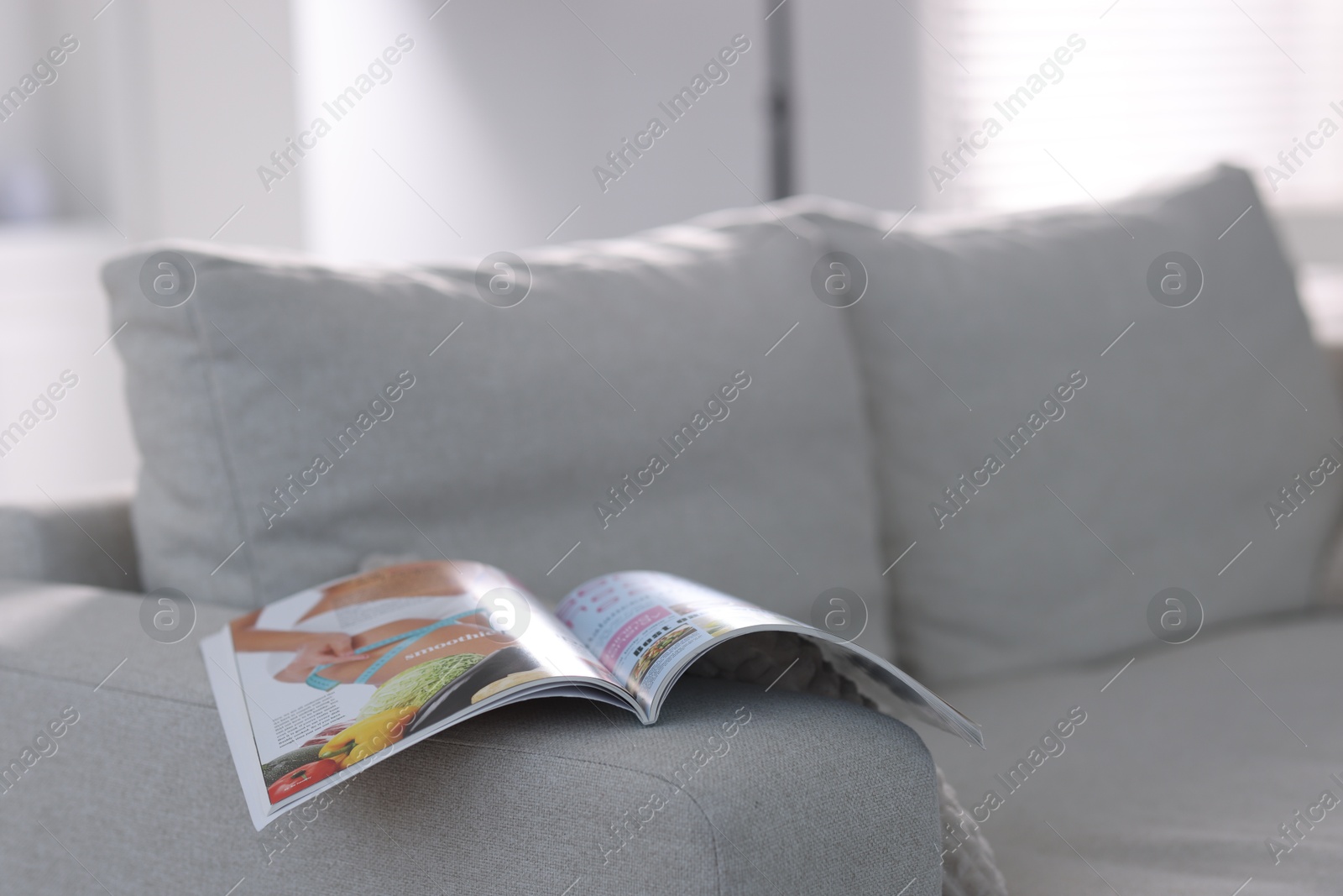 One trendy magazine on sofa indoors, closeup. Space for text Photo of One trendy magazine on sofa indoors, closeup. Space for text