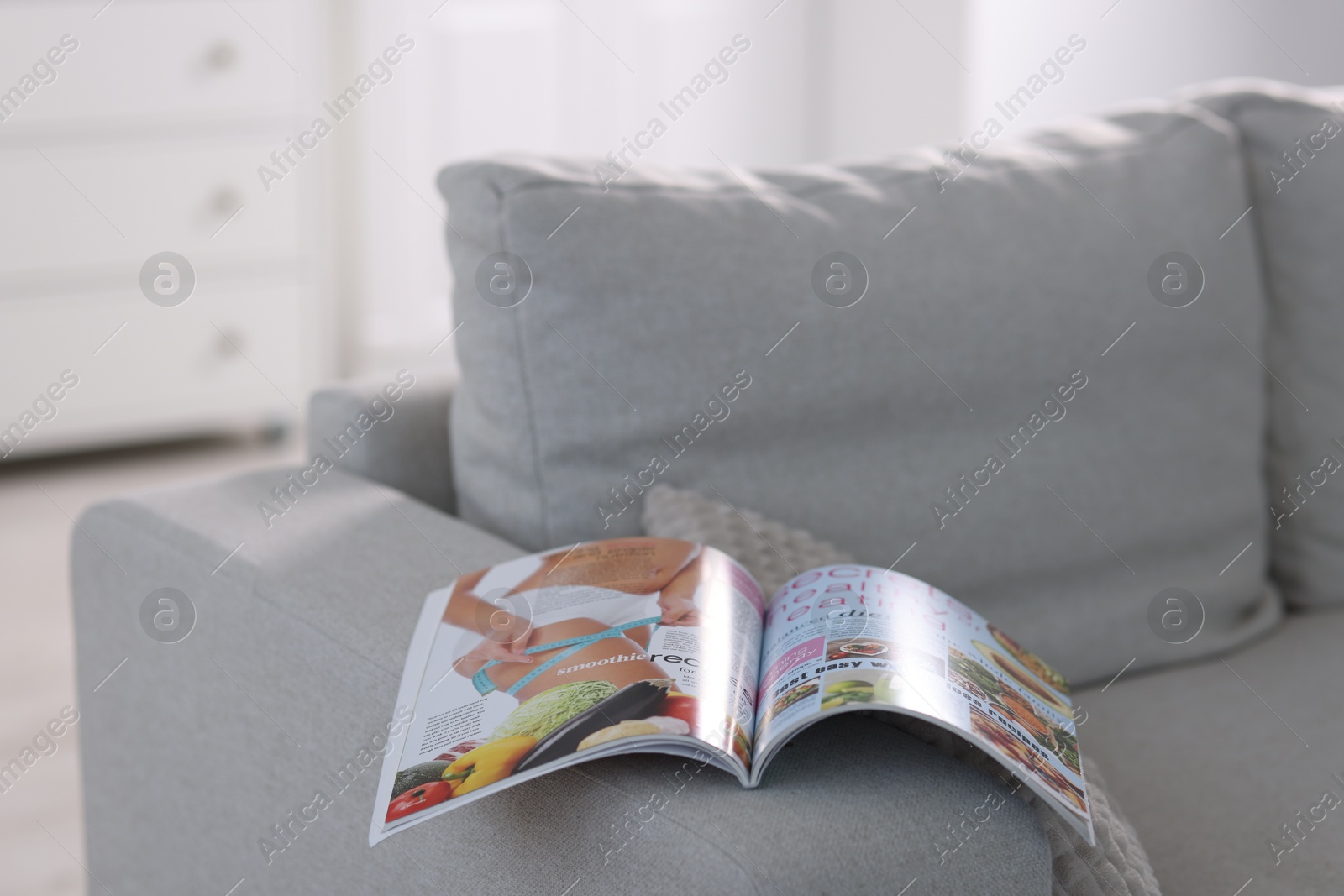 One trendy magazine on sofa indoors, closeup Photo of One trendy magazine on sofa indoors, closeup