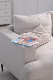 Photo of One trendy magazine on sofa at home
