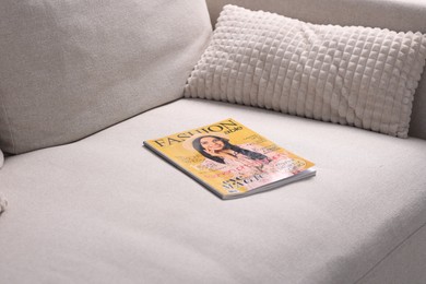 Photo of One trendy magazine on sofa at home