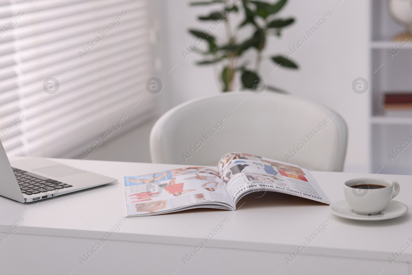 Open trendy magazine, laptop and coffee on white table indoors Photo of Open trendy magazine, laptop and coffee on white table indoors
