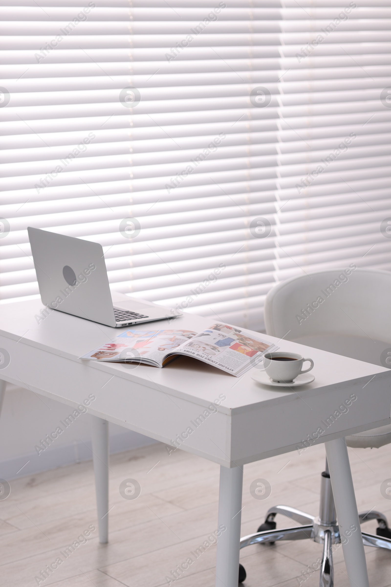 Open trendy magazine, laptop and coffee on white table indoors Photo of Open trendy magazine, laptop and coffee on white table indoors