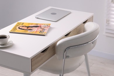 Photo of Trendy magazine, laptop and coffee on white table indoors