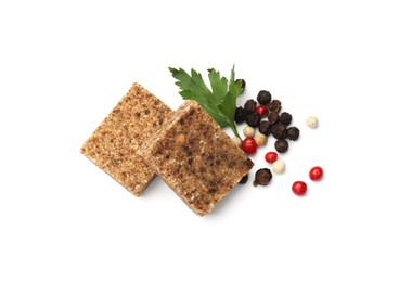 Photo of Aromatic bouillon cubes, parsley and peppercorns isolated on white, top view