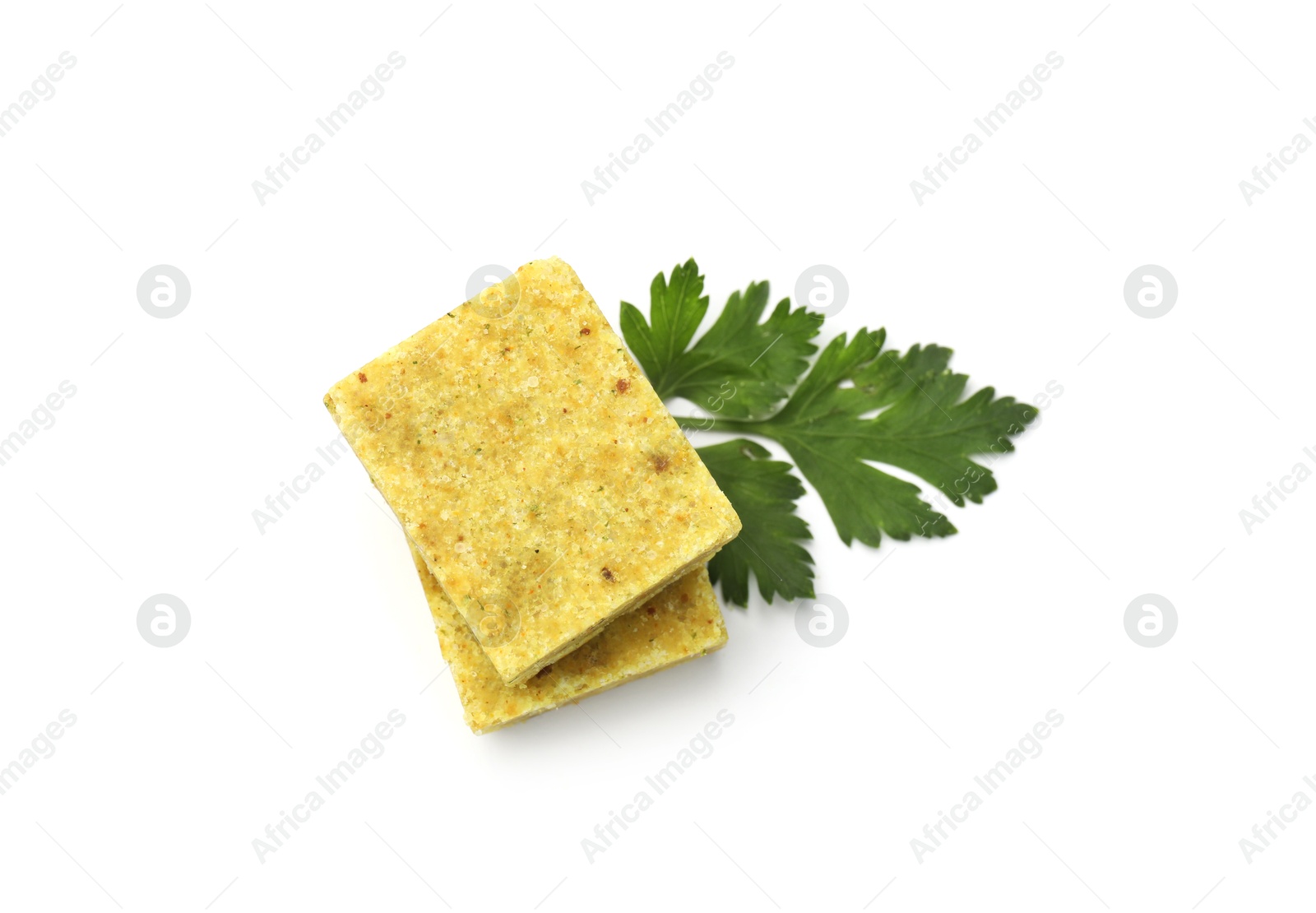 Aromatic bouillon cubes and parsley isolated on white, top view Photo of Aromatic bouillon cubes and parsley isolated on white, top view