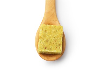 Photo of Aromatic bouillon cube and wooden spoon isolated on white, top view