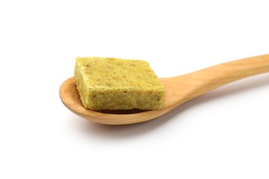 Photo of Aromatic bouillon cube and wooden spoon isolated on white