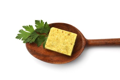 Photo of Aromatic bouillon cube, parsley and wooden spoon isolated on white, top view