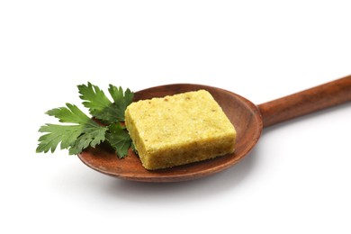 Photo of Aromatic bouillon cube, parsley and wooden spoon isolated on white