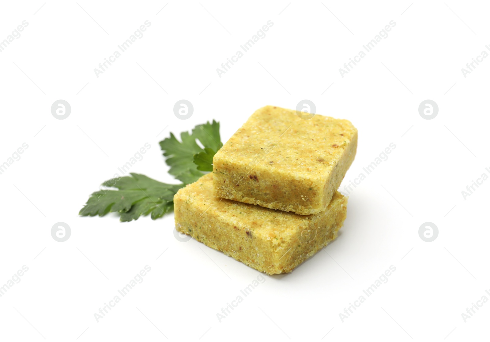 Aromatic bouillon cubes and parsley isolated on white Photo of Aromatic bouillon cubes and parsley isolated on white
