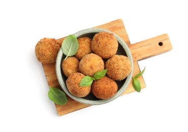 Photo of Delicious fried croquette balls with basil in bowl isolated on white, top view