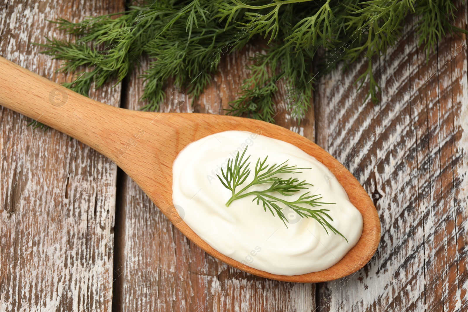Tasty sour cream with dill on wooden table, top view Photo of Tasty sour cream with dill on wooden table, top view