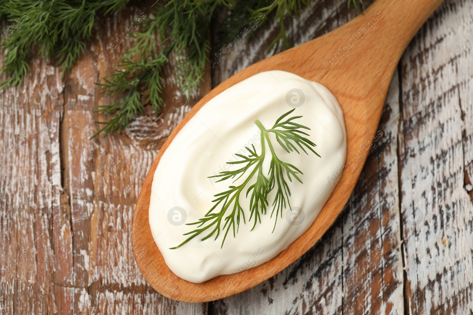 Tasty sour cream with dill on wooden table, top view Photo of Tasty sour cream with dill on wooden table, top view