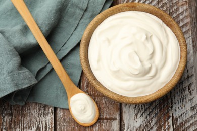Photo of Tasty sour cream on wooden table, flat lay