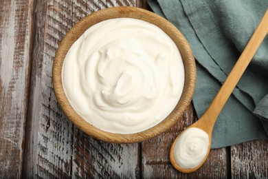 Photo of Tasty sour cream on wooden table, flat lay