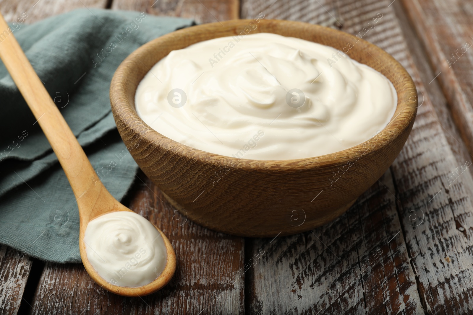 Photo of Tasty sour cream on wooden table, closeup