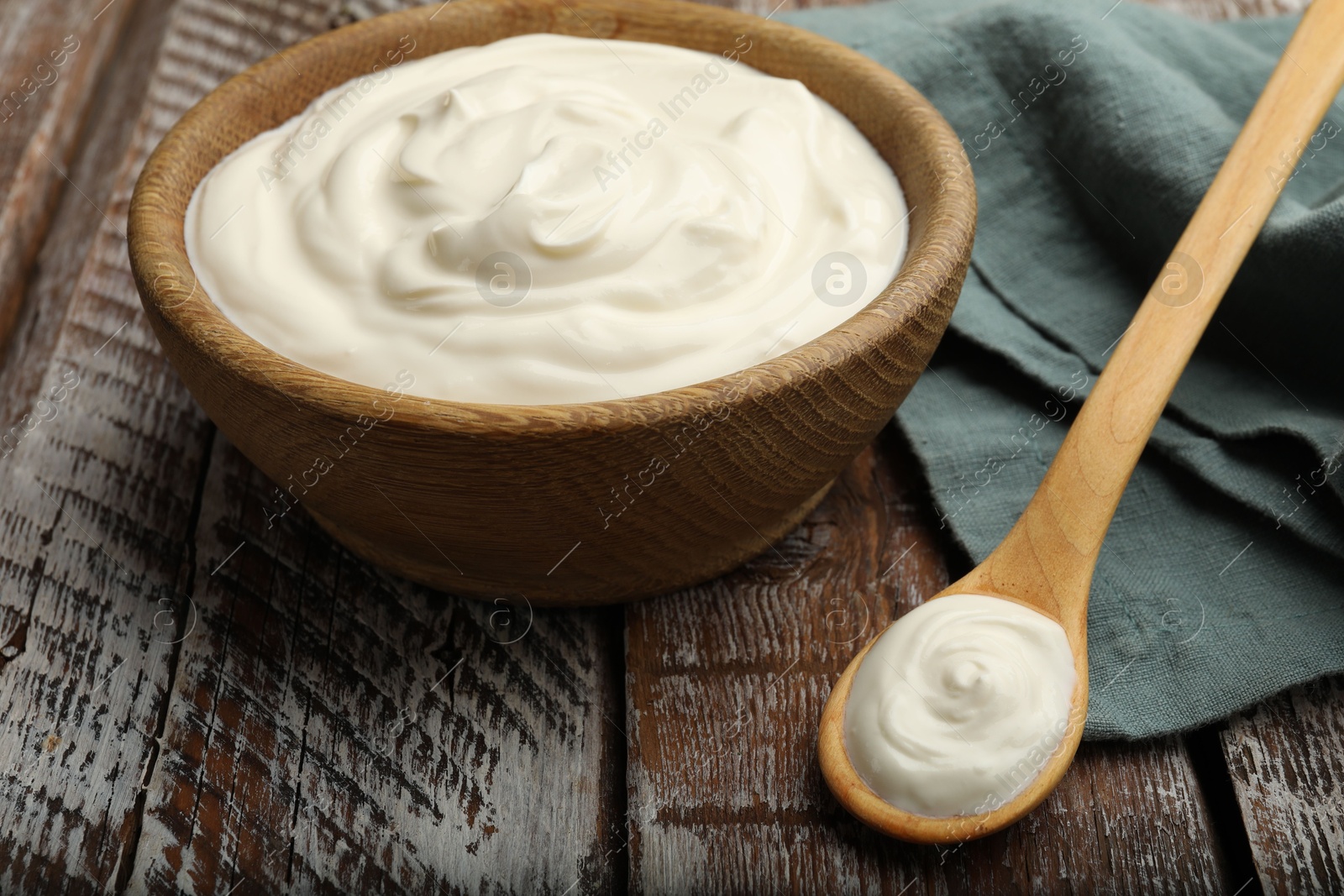 Photo of Tasty sour cream on wooden table, closeup
