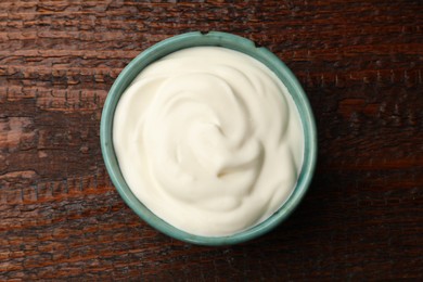 Photo of Tasty sour cream on wooden table, top view