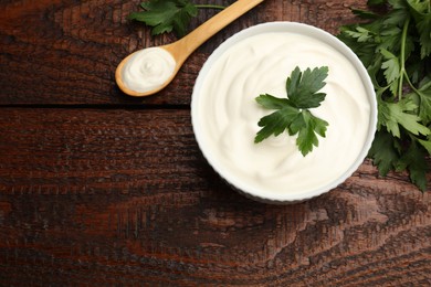 Photo of Tasty sour cream with parsley on wooden table, flat lay. Space for text