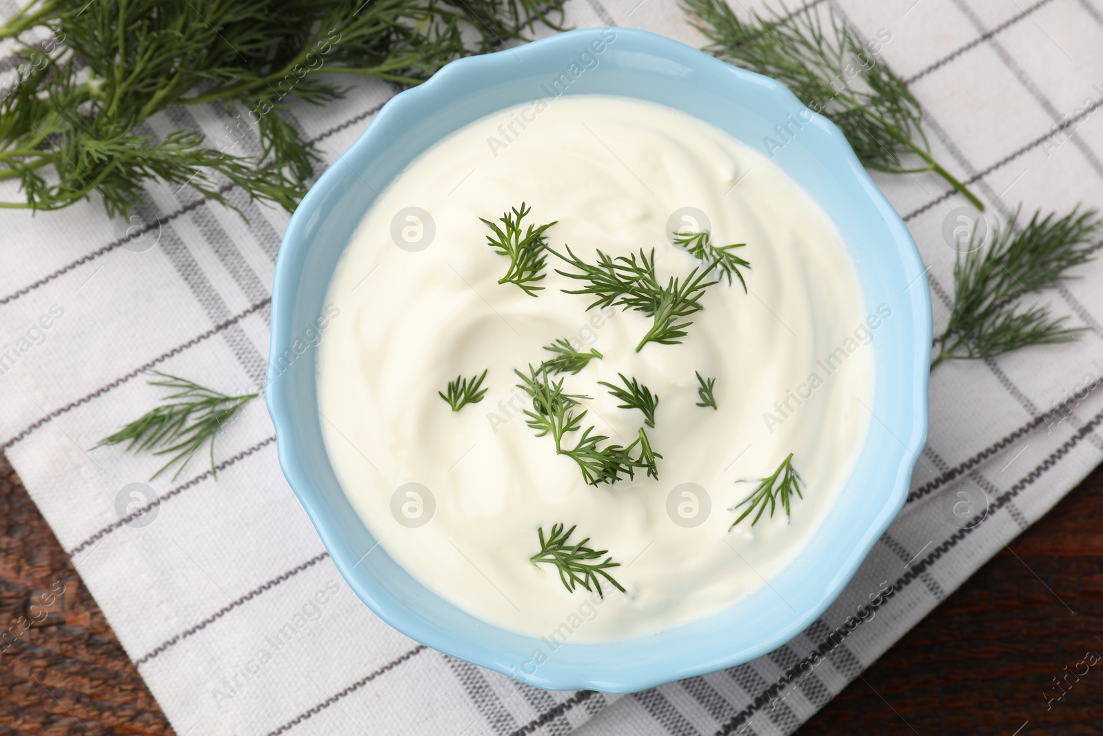 Photo of Tasty sour cream with dill on wooden table, flat lay