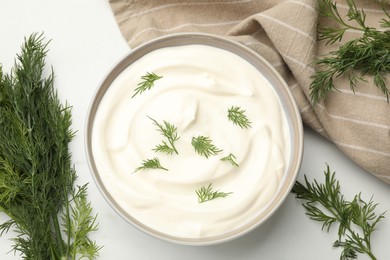 Photo of Tasty sour cream with dill on white table, flat lay