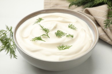 Photo of Tasty sour cream with dill on white table, closeup