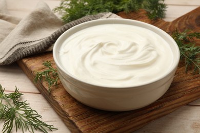 Photo of Tasty sour cream and dill on white wooden table, closeup